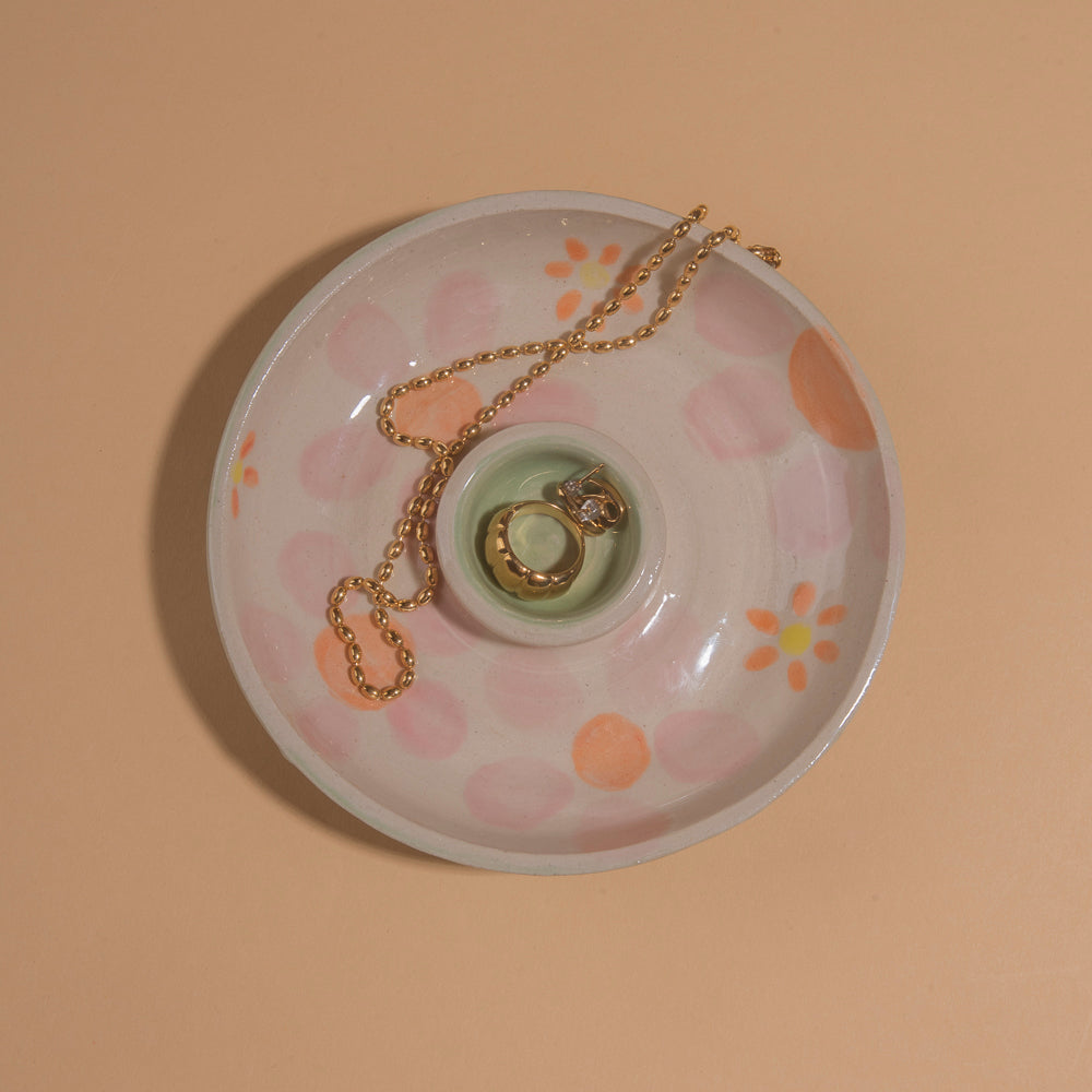 Circular two tiered accessory bowl with pink and orange painted flowers and an aqua center