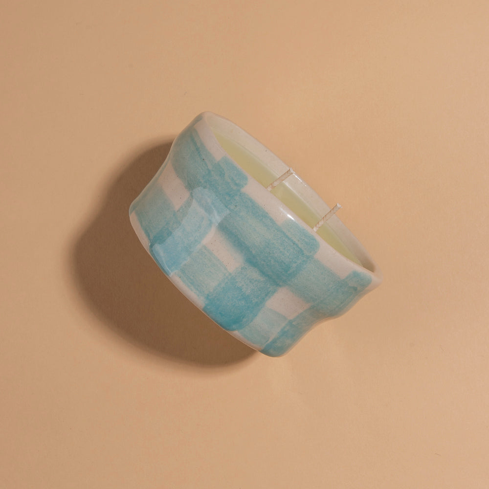 Double wick candle in ceramic holder with painted aqua coloured gingham pattern 