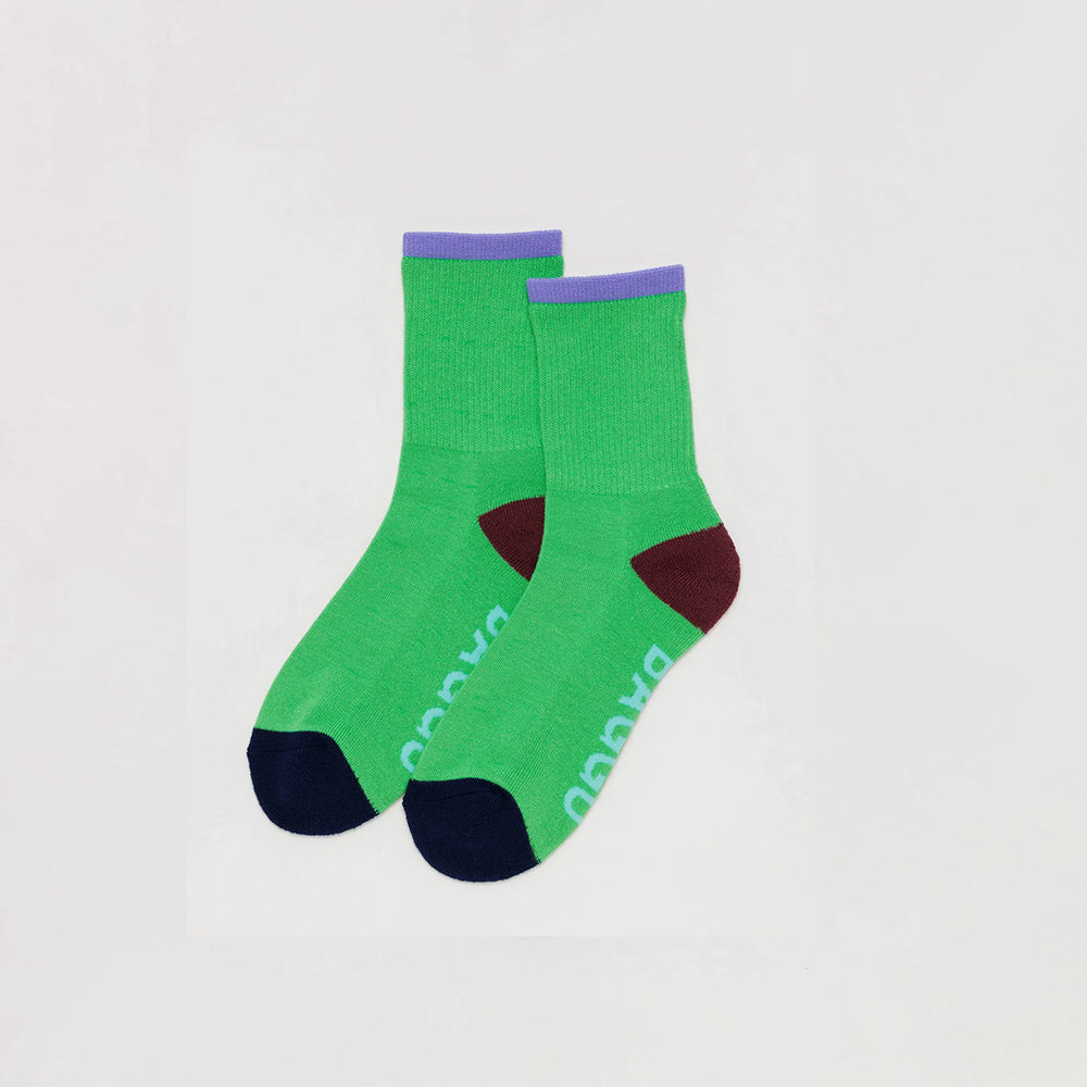 Bright Green Socks with Lilac Ankle Stripe, Brown heel, black colourblocked toes, and light blue "BAGGU" text on bottom of feet